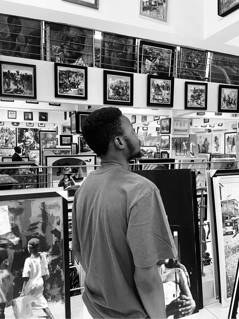 Olumide looking at art on a gallery wall